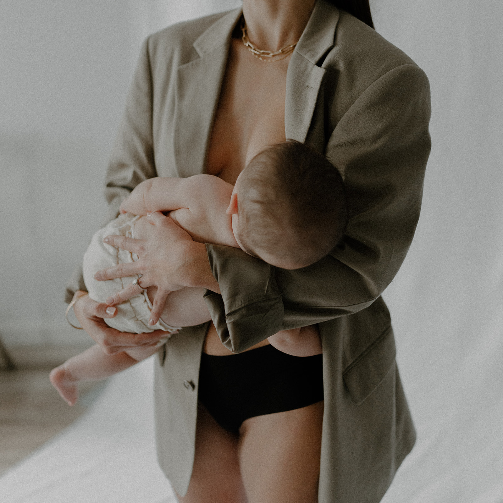 image of mom breast feeding while wearing a blazer