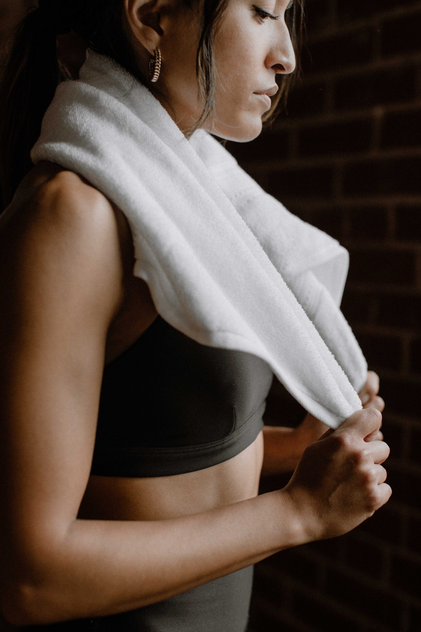 image of girl wearing workout clothes, towel over shoulder and wearing hoops