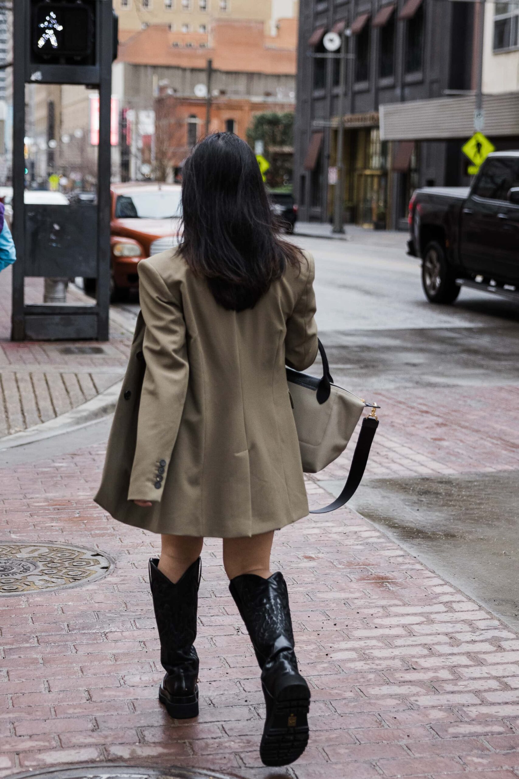 image of girl walking on street wearing blazer and cowboy boots