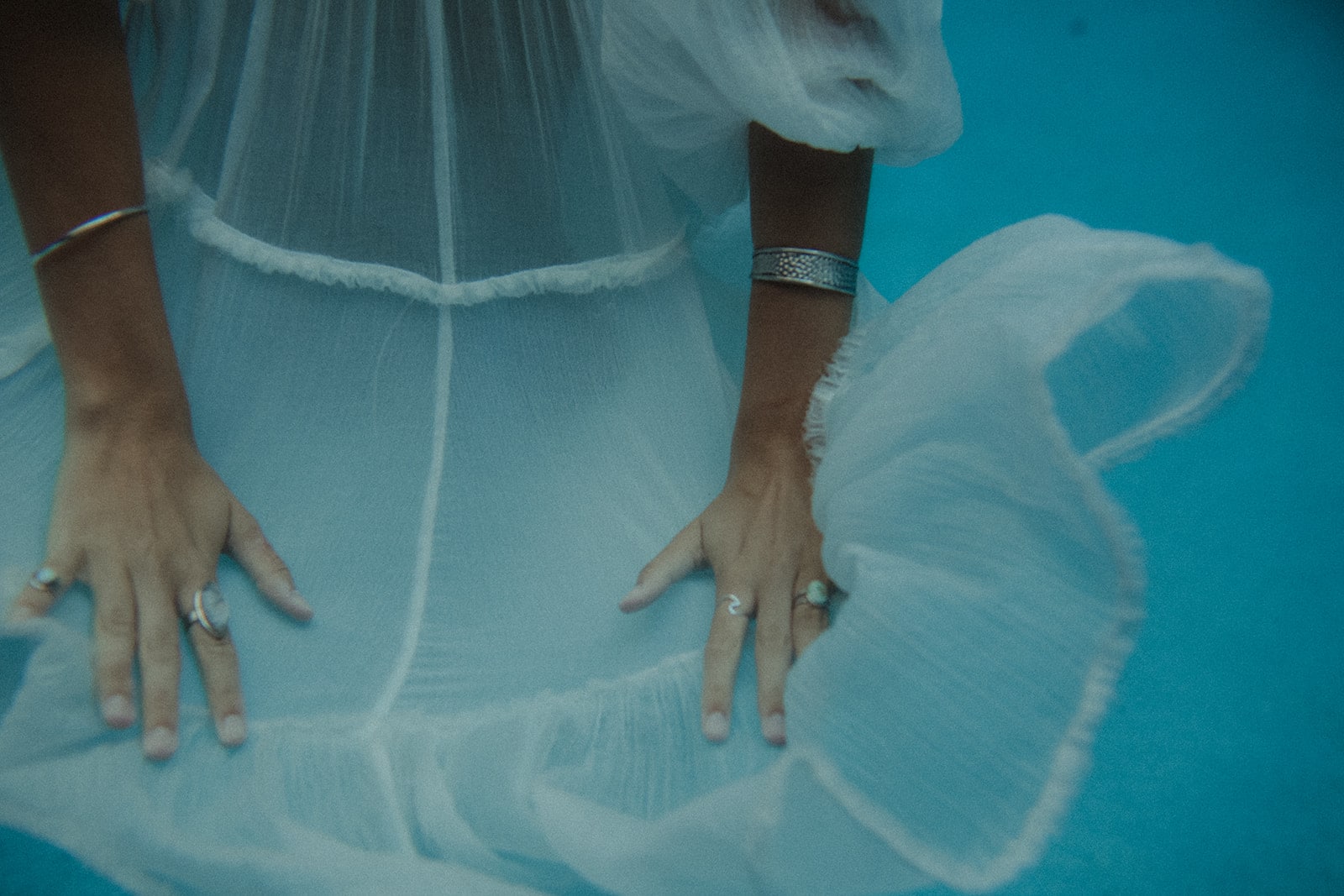 image of woman wearing white dress in blue water